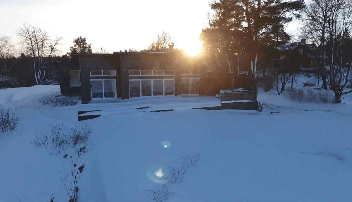 Modern cottage nestled on Tynningö island, surrounded by pristine snow-covered archipelago landscape with sunrise views and direct waterfront access.